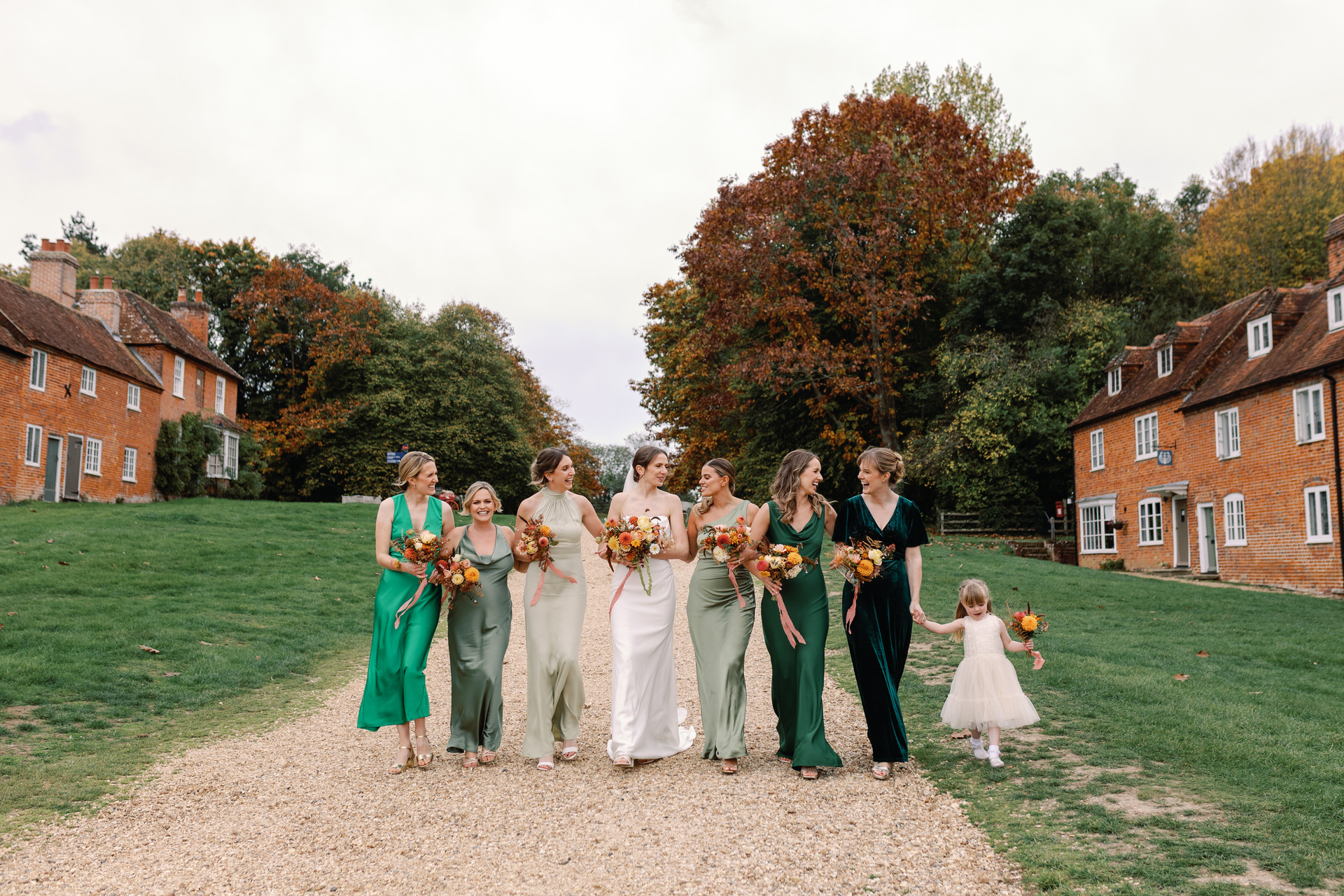 Bride and Bridesmaids hand in hand walking together smiling in the new forest